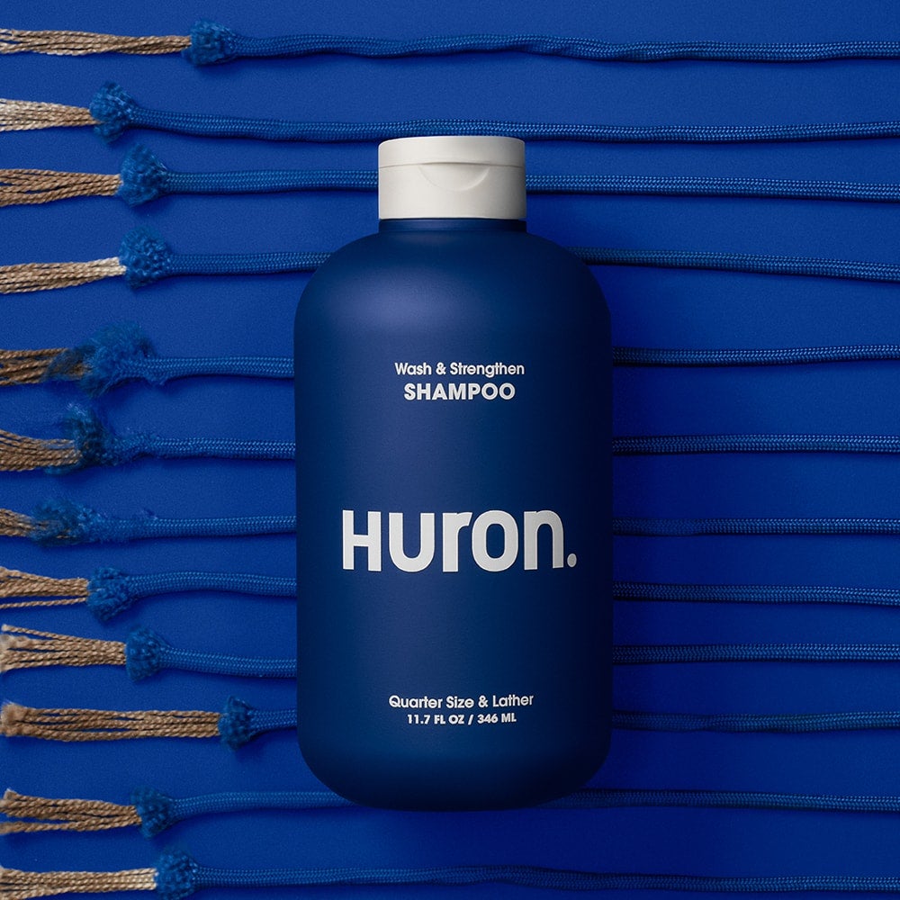 A bottle of shampoo lies against a dark blue background. 